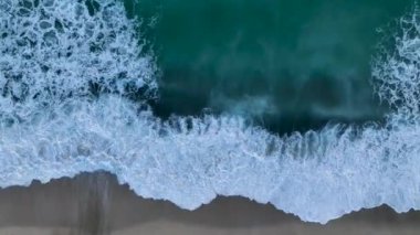 Güzel 4K tropikal plaj havası kuş bakışı okyanus dalgaları yukarıdan boş bir sahile çarpıyor.