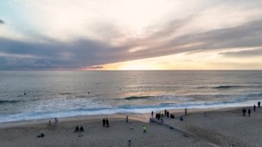 Waikiki sahilinde sörfçüler sabırla dalganın gelmesini bekliyor, sinematik çekim uçuyor.