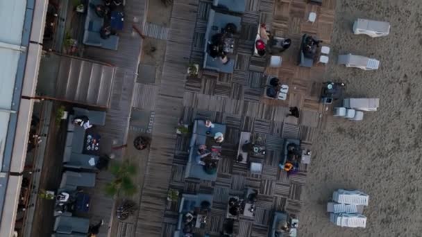 ドローントップビュー レストランテラス 地中海の海岸の隣にパラソル付きの砂浜 — ストック動画