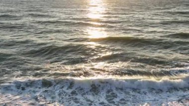 Güneş parlayan mavi denize yansıyor, gün batımında okyanus, gündoğumu hava manzarası 4k yavaş çekim