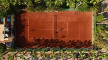 Tenis kortunun üstünde uçan en iyi atış. Tenis kortunun üst raundu. Gün boyunca yeşil park bölgesindeki tenis kortları.