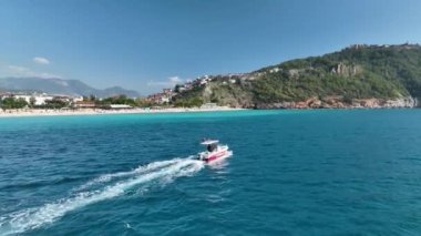 Büyük balıklarla uçan bir balıkçı teknesi. Dönen aç martılar. Havadan seyyar dron sürüsü. Deniz yüzeyinde yüzen küçük bir gemi, deniz köpüğü sularından oluşan bir yol bırakır. Üst görünüm