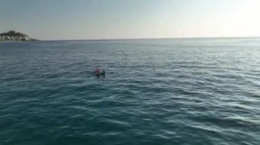 Güzel bir çift, el değmemiş turkuaz suyu kürek tahtasında keşfediyor. İki Kafkasyalı sakin suların tadını çıkarmak için kürek çekiyor..