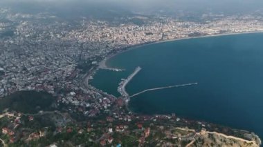 Bulutların arasından pürüzsüz bir uçuş. Liman ve şehir manzarası açık.