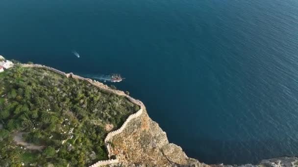 一艘大型海盗船在土耳其阿拉亚市的史诗般的岩石和一座巨大的古堡的背景下航行 — 图库视频影像