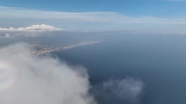 Alanya şehrinin eski kalesinin üzerindeki bulutların aşağı doğru eğimli görüntüsü, insansız hava aracı limanın üzerinde uçuyor.