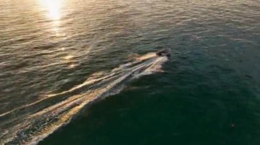 Motorlu aracın turkuaz denizde yüzüşünü gösteren drone görüntüleri..