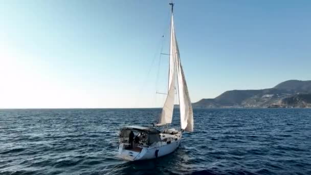 セーリングヨットは山の地平線に晴れた日に青い海に行きます — ストック動画