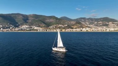 Yelkenli altında yat yarışları. Yelkenli açık denizde yansıyor. Yarış yatı deniz manzaralı. Yaz gezisinde lüks bir tekne.