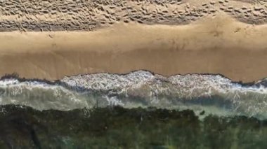 Bir yaz günü kumsalın tepesindeki drone 'lar kumlu sahil şeridinde dalgalanırken.