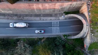 Yol manzaralı Alanya kıyı şeridi üzerinde uçan insansız hava aracı, bitki örtüsü ve kayalarla kayalık kıyı şeridi ve açık köpüklü dalgalarla açık deniz