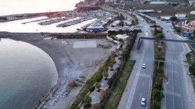 Türkiye 'nin Port Alanya kentindeki lüks deniz bölgesinin havadan geniş bir görüntüsü. İHA 'daki kamera birden fazla yelkenli yatın ve teknelerin üzerinde kıyıya doğru uçuyor.