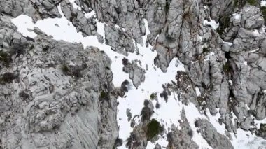 Dağlar ve hızlı cesur kayakçılar kış ormanlarındaki karlı tropik bölgelerde iniyor, UHD 4K video.