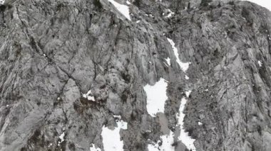 Dağ Kayalıkları Yüzeyi 4K 'ya yakın. Geniş açılı insansız hava aracı, dağların dramatik zirvelerinden sorunsuzca yükseliyor.