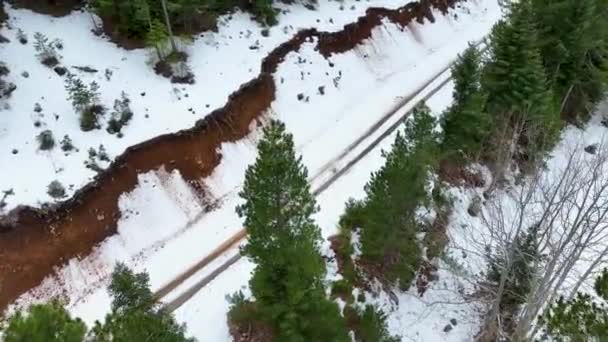 冬季空中俯瞰高山蜿蜒的道路和驾驶汽车 史诗般的 雪白的冬天和白雪覆盖的森林 — 图库视频影像