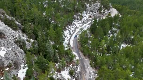 雪上山道で車を運転冬に山のツイスト道路の空中ビューと車を運転 叙事詩 雪の白い冬と雪の森のキャップ — ストック動画