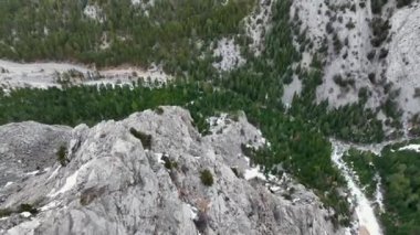Kayalık arazide akıntıyla akan vahşi bir dağ nehri. Suyun canlı yeşil bir rengi var. Su kayalara çarpar ve çok güzel doğal bir manzara yaratır..