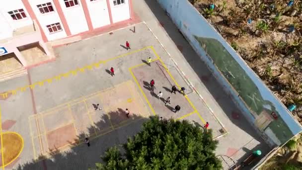 晴れた日の学校では ドローンは右にスムーズに移動し 子供たちはサッカーをします — ストック動画