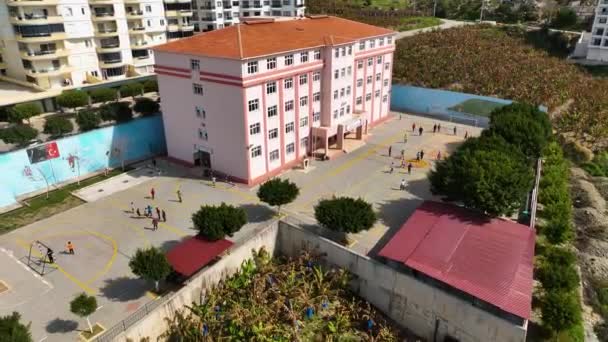 在阳光灿烂的日子里 土耳其中学的概况是 无人驾驶飞机在轨道上平稳地向右转 孩子们踢足球 — 图库视频影像