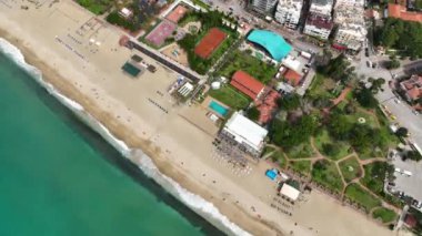 Alanya 'daki Kleopatra Sahili' nin oradaki bir kafenin huzurlu kıyı dalgalarına dalmak. İnsansız hava aracımız, gök mavisi Akdeniz 'in nefes kesici manzarasını yakalıyor ve videolarınızı büyüleyici kılıyor..