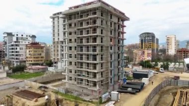 İHA 'mız cephe çalışmalarını, zemin kurulumlarını ve bulut kaplı atmosferdeki lüks evlerin çatı hazırlıklarını çekerken inşaat konseptini sinematik detaylarıyla izleyin.