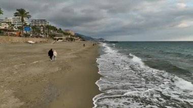 Kışın kumsalda yürüyüşe çıkan genç bir çifte katılın. Sinema robotumuz neşelerini yakalayıp, havanın ve ferahlatıcı deniz esintisinin tadını çıkarıyor..