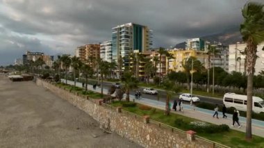 Sinematik dronumuz gezinti güvertesinde palmiye yaprakları rüzgarda zarif bir şekilde dans eden insanları yakalarken rüzgârın dinginliğini tecrübe edin..