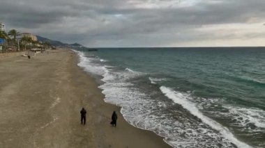 Rüzgarın fısıltılarını dinleyin. Sinematik drone filmlerimiz gibi insanlar gezinti güvertesinde yavaşça yürüyor. Palmiye yaprakları rüzgarda zarifçe sallanıyor..