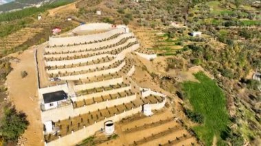 Sinema insansız hava aracımız Güney Türkiye 'deki görkemli avokado çiftliklerini ele geçirirken tarım arazilerinin zenginliğini gözler önüne seriyoruz. Teraslı avakado bahçeleriyle çevrili küçük otantik evleri deneyin.