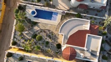 Profesyonel dronumuz seçkin villa kompleksini ele geçirirken klasik cazibe dünyasına adım atın. Çekici havuzdan.