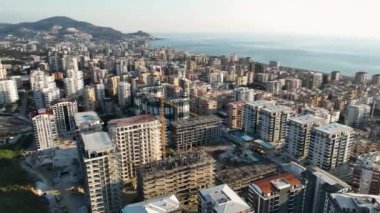 Profesyonel İHA 'mız, büyüleyici Akdeniz kıyı şeridinde çok katlı binaların yapımını titizlikle yakalar..