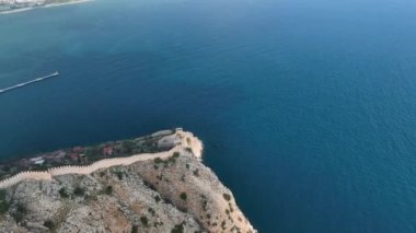 Türkiye 'nin büyüleyici kenti Alanya' da manzaralı bir yolculuğun tadını çıkarın. İnsansız hava aracı antik kalede yüzyıllardır kullanılan evleri gezen üstü açık arabanın görüntüsünü sunuyor.