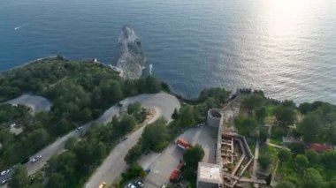 Alanyas tarihi boyunca bir yolculuğa çıkın. İnsansız hava aracı, yüzyıllardır var olan evlerin özünü yakalayarak, eski kalenin içinden geçen üstü açık arabaların yolunu belgeliyor.