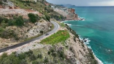 Türkiye 'nin Alanya kentinin büyüleyici sahil güzelliğine kaçın. İnsansız hava aracı, antik kalede zikzak çizen üstü açık arabayı takip ediyor.