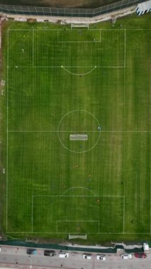 Bir futbol takımının yemyeşil bir alanda antrenman yapmasını gösteren dikey bir videonun heyecanını yaşayın. Oyuncuların atletik hareketlerini sergiledikleri enerji, beceri ve adanmışlığa tanık olun.
