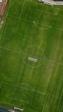 Dinamik bir futbol antrenmanını görüntüleyen dikey bir videonun heyecanına dalın. Oyuncuları canlı yeşil çimlerde, takım çalışması ve tutku gösterilerinde izleyin.