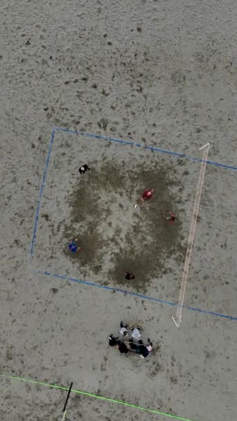 观看激烈的排球赛在海滩上在这个垂直的视频 在阴云密布的条件下体验球员的竞争精神和精力 — 图库视频影像