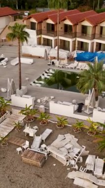 Bu çarpıcı dikey videoda çekilen fırtınadan sonra bir yaz plaj kafesinin sükunetine kapıl. Geniş havuz ve rahat şezlonglar rahatlatıcı ambiyansı artırıyor..