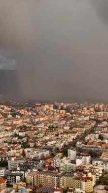 İHA 'nın, bulutlu bir prizmanın içinden canlı renkleriyle parlayan çift gökkuşağını, kasırga yağmuru eşliğinde yakalaması hayret verici bir manzara.