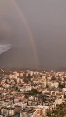 Gökkuşağının görkemli güzelliğine hayran olun. Bir dron Alanya 'nın üstündeki gökyüzünü süsleyen canlı renkleri yakalıyor. Nefes kesici manzara ve resim gibi arkaplan büyüleyici bir görsel yaratıyor.