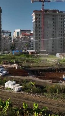 Bu dikey videoda, Akdeniz kıyıları ve dingin yeşil plantasyonları göz kamaştırıcı manzaralı evler inşa edilmesine tanık olun..