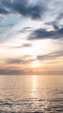 Derin mavi denizin üzerinde gün batımının ışıltılı güzelliğinin tadını çıkar. Göksel renk eğimini ve suların kalitesini gözlemleyin. Güneş ışınlarını parlak bir şekilde yansıtıyor. Kozmik