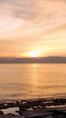 Alanya 'da deniz günbatımının huzurlu anlarına tanık olun. Güneş zarif bir şekilde alçalıyor ve suların üzerine sıcak bir parıltı saçıyor..
