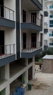 Evler dramatik ve bulutlu hava koşulları altında şekillenirken bu dikey videoda ev yapımının esnekliğine tanık olun.