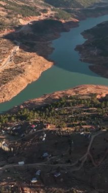 Dağ nehrinin etrafındaki güzelliği yansıtan yansımalarına hayret edin. Bu dikey video dingin atmosferi ve çarpıcı görselleri yakalar ve canlı bir duvar kağıdı oluşturur.