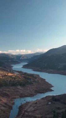 Yükseklerde süzülen bir İHA 'nın perspektifini yakalayan bu dikey videoyla muhteşem dağların kuş bakışı görüntüsünü alın..