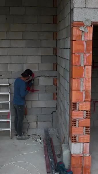 厳しい天候の中で住宅を建てるために雨に抵抗する建設労働者の決意を垣間見る — ストック動画