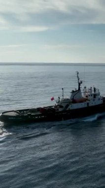 Bir römorkörün dingin mavi denizi geçişini hissedin. Bu dikey video deniz meraklıları için huzurlu ve huzurlu bir duvar kağıdı oluşturuyor..