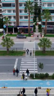 Bu dikey videoda kış gezintisini yaşayın, insanlar deniz kenarında rahatça dolaşırken, serin deniz esintisinin ve manzaranın tadını çıkarırken..