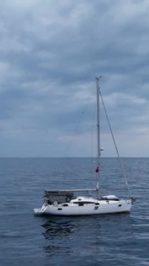 Bu dikey videoda beyaz bir yatın limana girdiği kış yatlarının sükunetini yaşayın. Huzurlu atmosferin ve yelkenli teknenin güzelliğinin tadını çıkar..